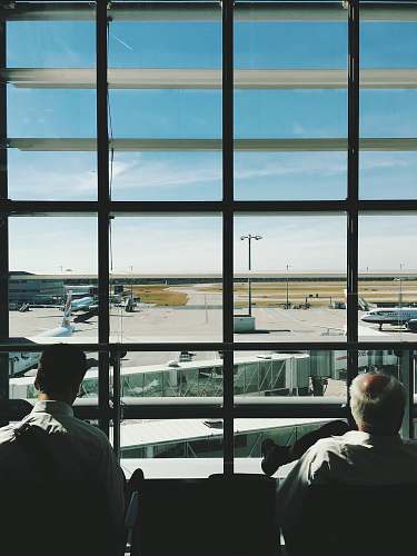 person two men sitting in front of glass window during daytime human