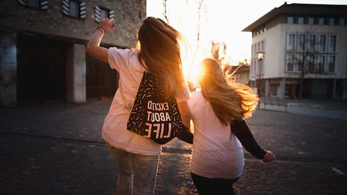 person two women walking across the road during sunset human