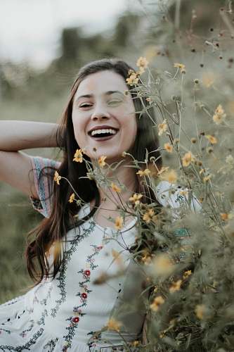 human woman behind yellow petaled flowers person