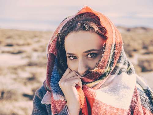 person woman covering her face with red and white scarf human