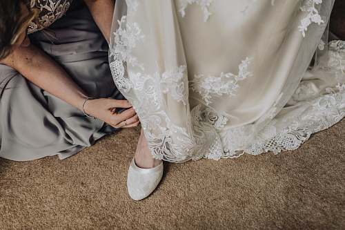 human woman fixing shoes of another woman person