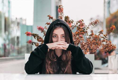 human woman in black hooded jacket by brown plant plant