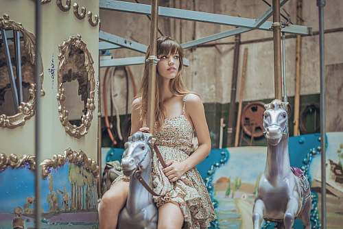 person woman in gray floral dress riding carousel human