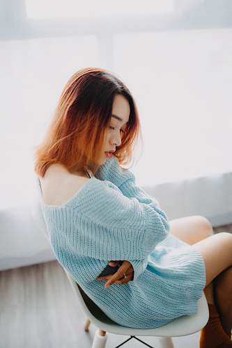human woman in teal knitted dress sitting on chair person