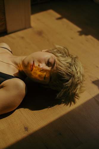 person woman lying on brown wooden surface human