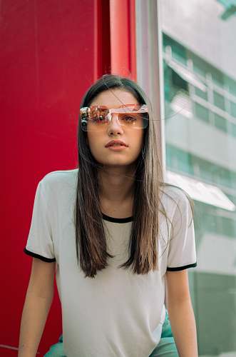 person woman sitting beside red wall human