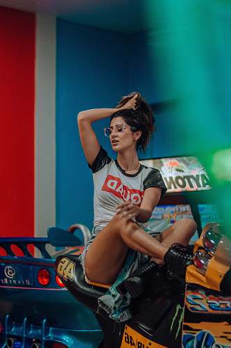 human woman sitting on blue and yellow ride-on toy car person