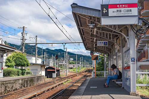 person woman sitting on canopy while waiting train human