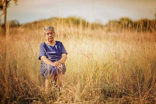 person woman sitting on chair and surrounded by grass human