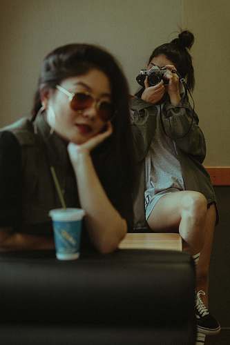 person woman sitting on chair while taking photo cup