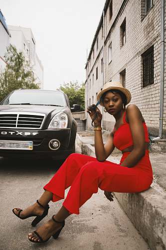 person woman sitting on floor near black vehicle human