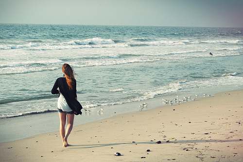person woman standing at seashore beach