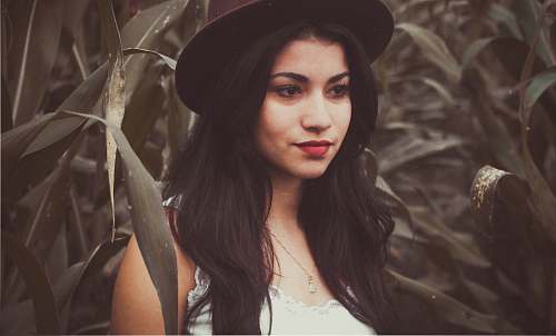 person woman standing in front of green leafed plants human