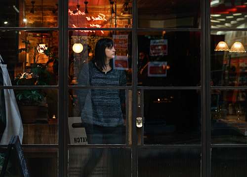 person woman standing near glass window vase