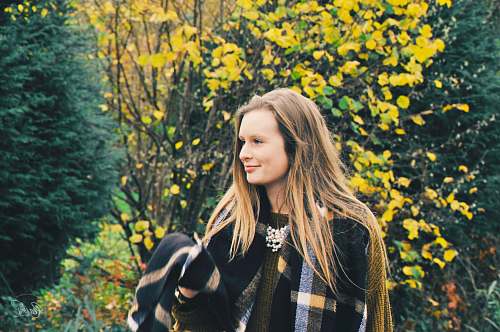 human woman standing near green and yellow foliage tree woman