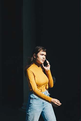 person woman walking with phone on her right ear during daytime human