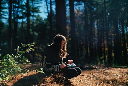 person woman wearing black and gray top sitting during daytime human
