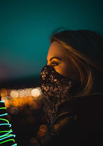 person woman wearing black and white floral face mask during nighttime human