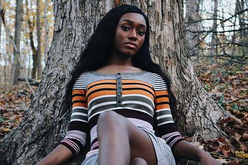 person woman wearing striped shirt laying near tree human