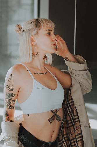 person woman wearing white Nike sports bra and brown and black plaid jacket human