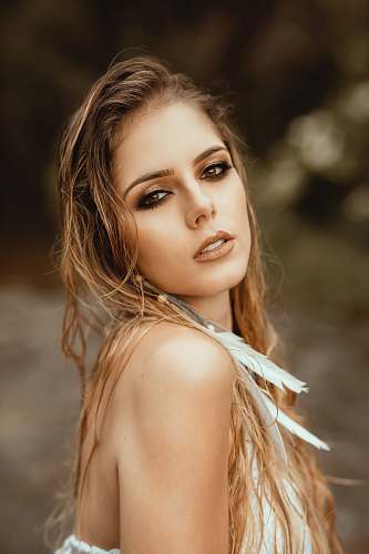 people focus photography of blonde woman with feather earring human