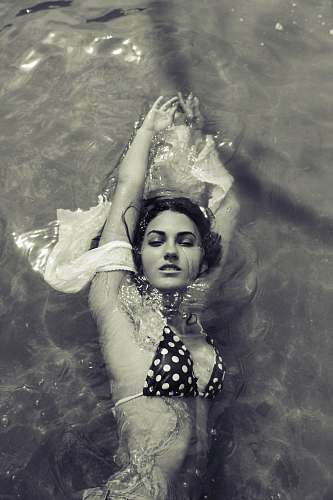 human greyscale photography of woman swimming people