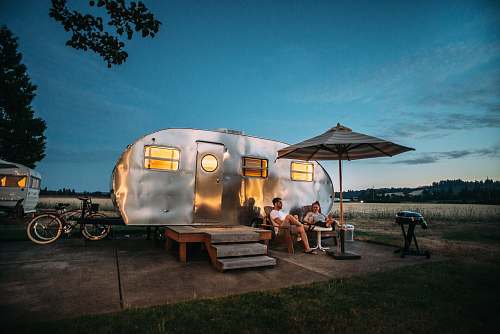 people man and woman sitting in front of RV trailer human
