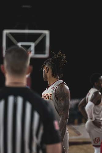people man in black jersey shirt standing in front of man in white jersey shirt human