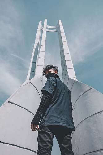 people man in black shirt standing at the front of tower grey