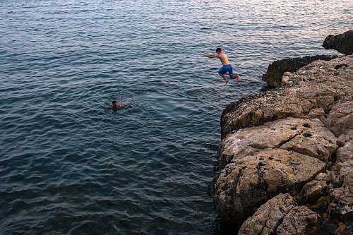 people man jumping on cliff human