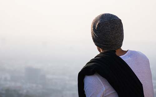 people man looking high rise buildings hat