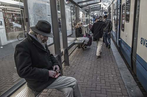 train man sitting on waiting bench in train station train station