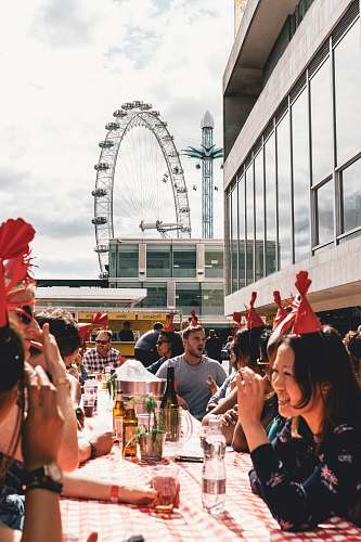 people people dining outside building near ferris wheel human