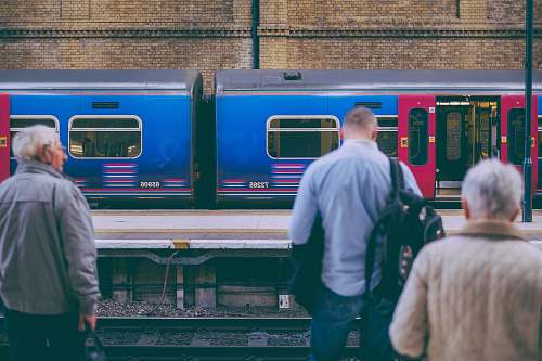 people person in gray dress shirt standing in front of train rail human