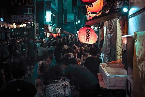 human photo of people gathering in market during nighttime people