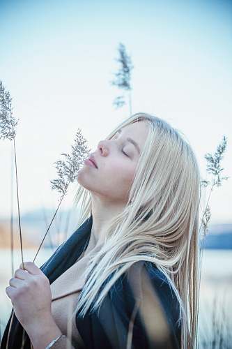 people selective focus photo of woman holding green plant during daytime human