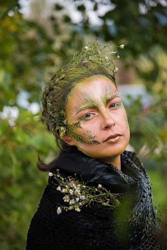 human selective focus photo of woman with nature-themed makeup people