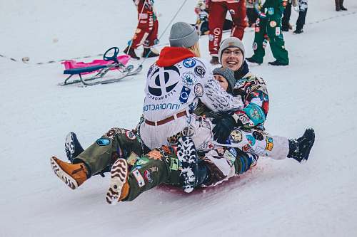 snow three persons riding on sled people