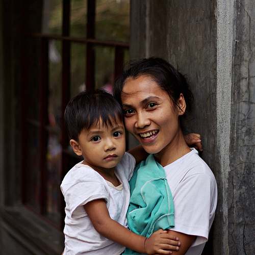 people woman carrying a boy near metal frame human