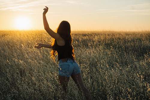 people woman dancing at green grass field during sunset human