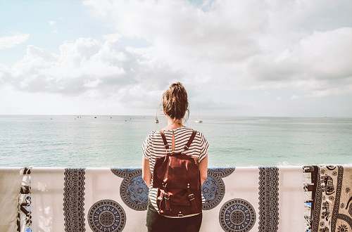 people woman standing in front of body of water during daytime human