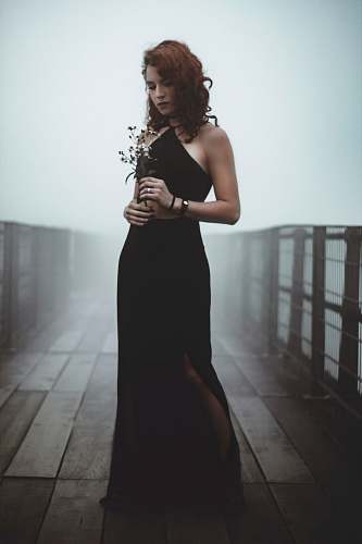 human woman standing in the bridge while holding flowers people
