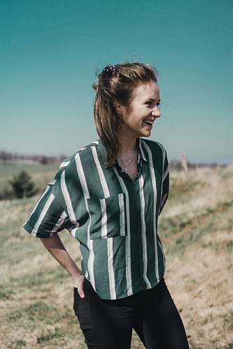 people woman standing on green grass while hands in black pocket human