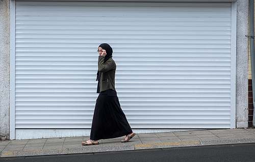 people woman walking beside closed roll-up door human