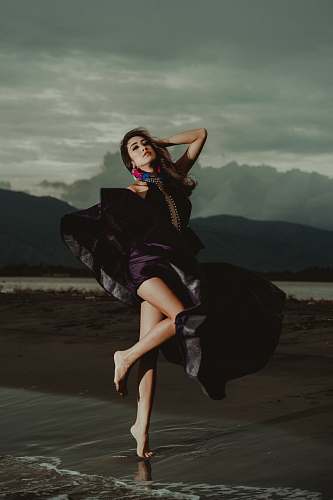 people woman wearing purple dress standing on shoreline human