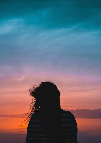 people woman wearing striped standing under cloudy sky human