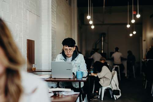 people woman wearing white jacket using laptop computer human