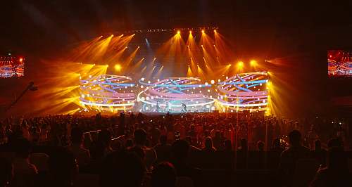 human crowd in front of lighted stage person