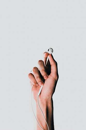 apple person holding Apple EarPods headphone