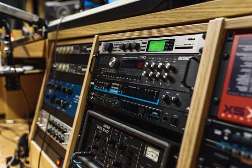 stereo black audio mixer in brown wooden shelf recording